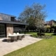 Complete tuinrenovatie Waalwijk met grote terrastegels, gazon, overkapping en sierbeplanting