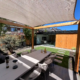 Luxe zitplek in een onderhoudsvriendelijke tuin onder een pergola met verstelbaar schaduwdoek